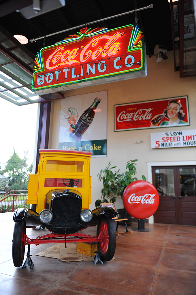 An old-fashioned delivery truck surrounded by vintage Coca-Cola signage at the Biedenharn Museum in Monroe.