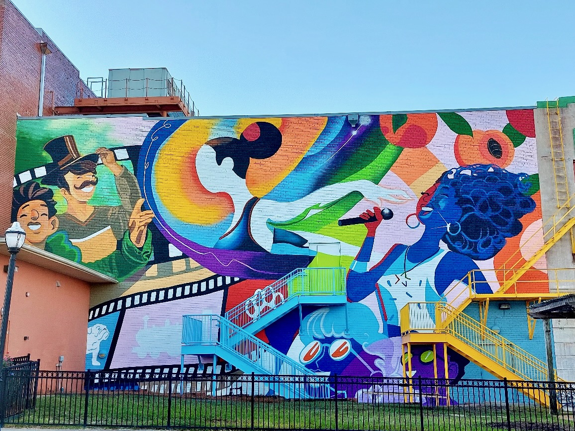 Mural celebrating the arts, on the side of the Dixie Center for Performing Arts.