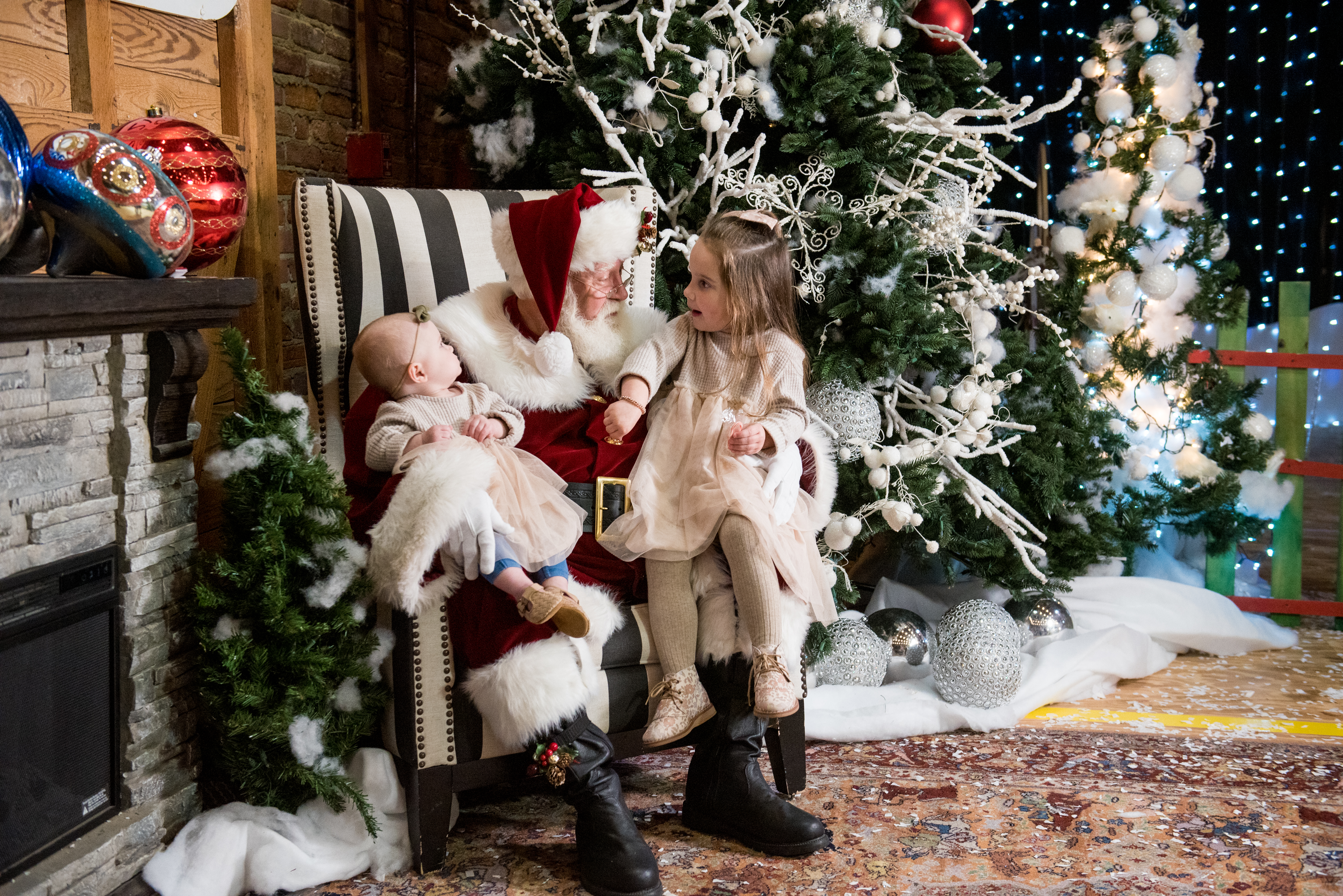 A child and a baby sit on Santa's lap in Santa's Christmas Village in Monroe, Louisiana.