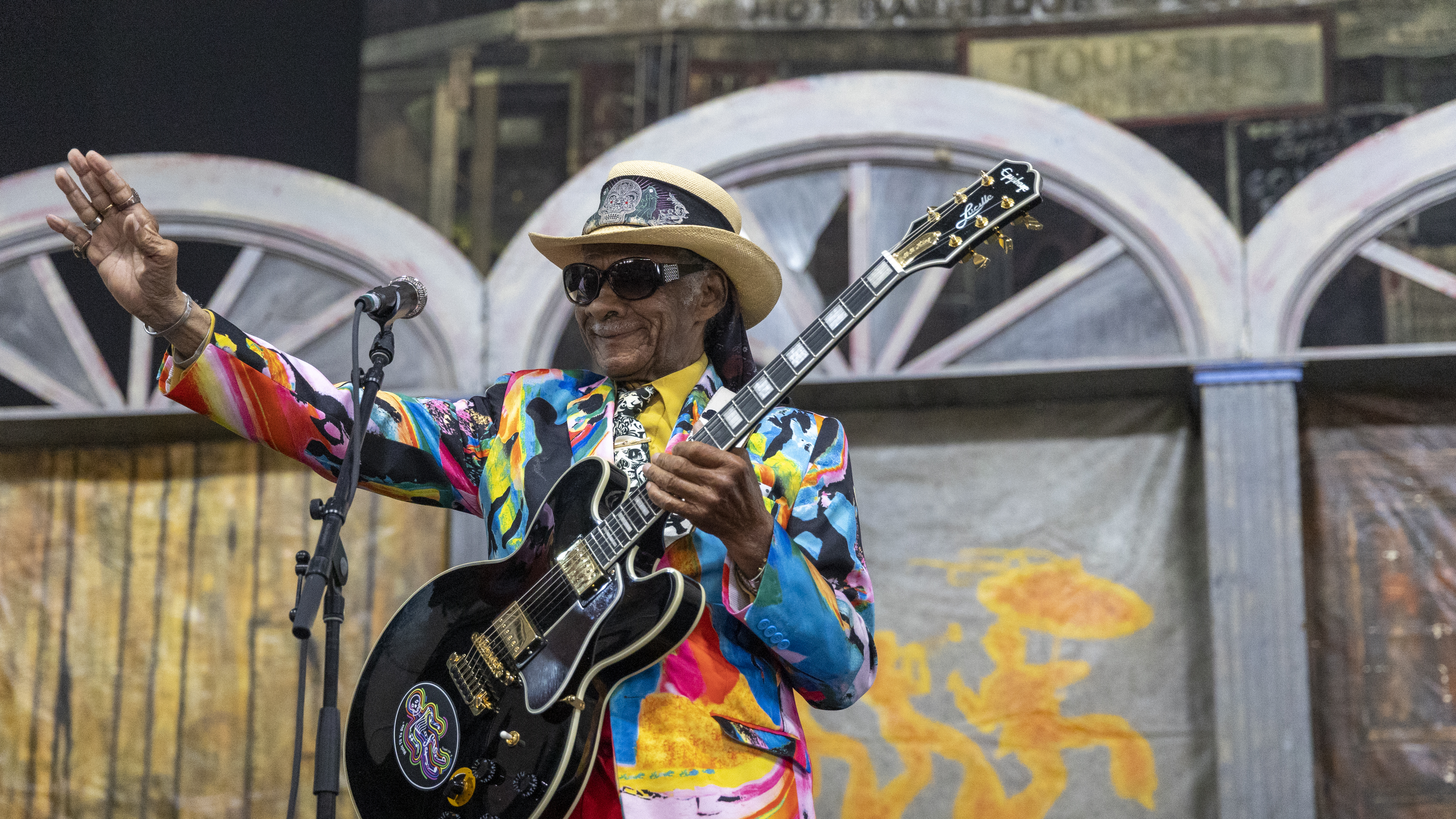 A. blues performer smiles at a JazzFest crowd.