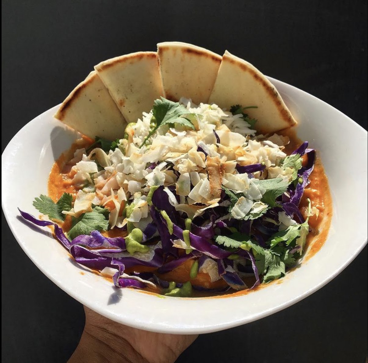 A veggie-forward dish with pita bread triangles on the side from MJ's Cafe