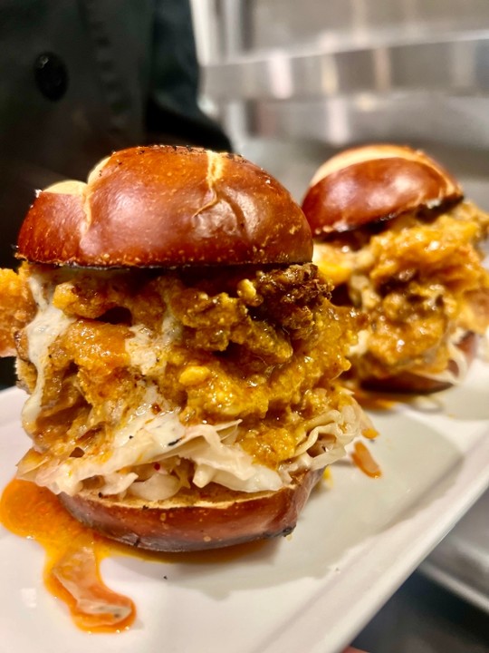 an onion-ring-covered burger from Plantry Cafe in Baton Rouge drips with sauce