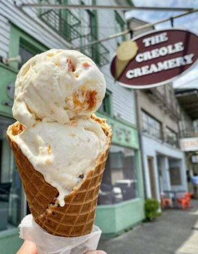 A waffle cone holds two scoops of creamy ice creams outside The Creole Creamery in New Orleans.