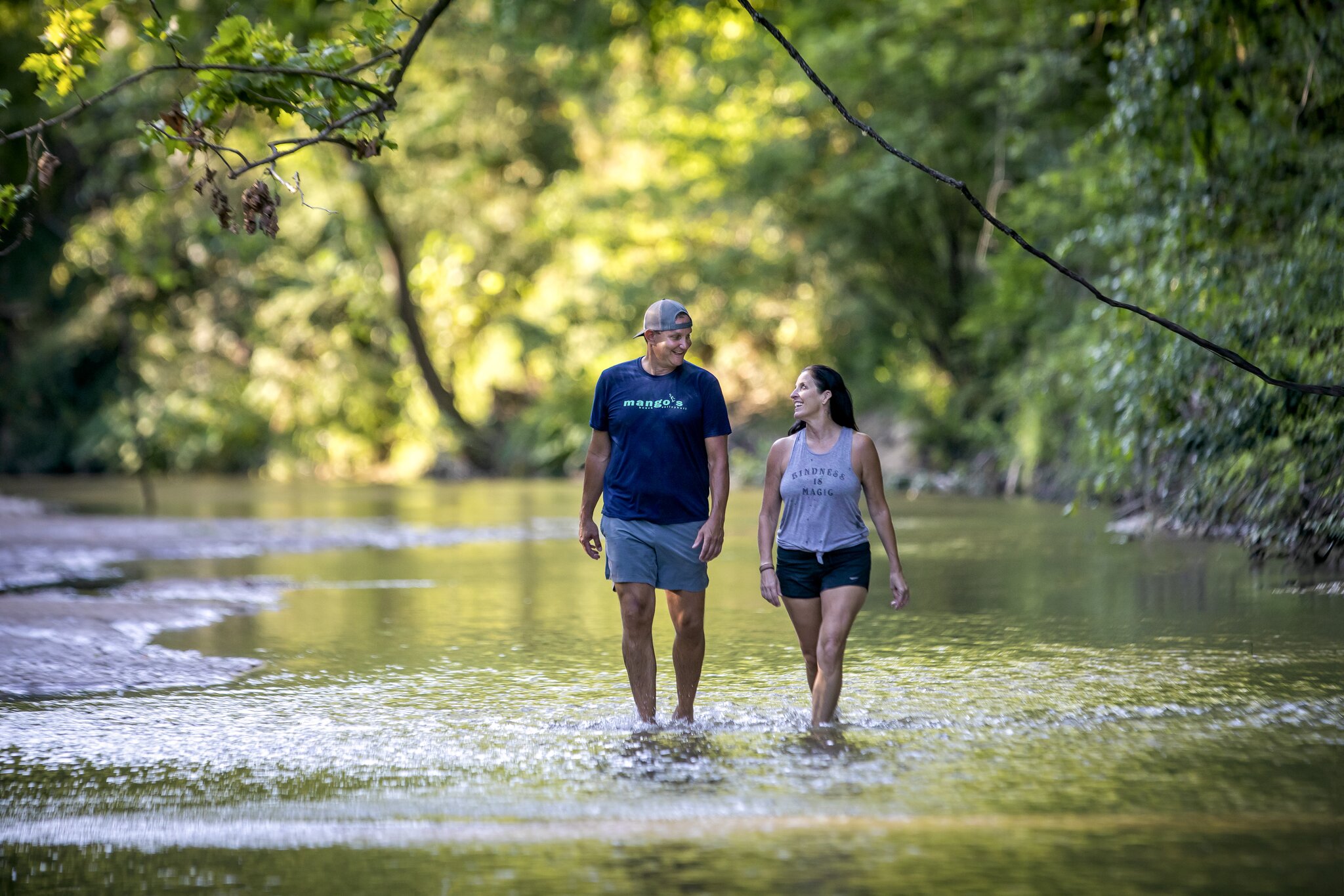 A couple walks through ankle-deep water in the forests of the Tunica Hills Wildlife Management Area.