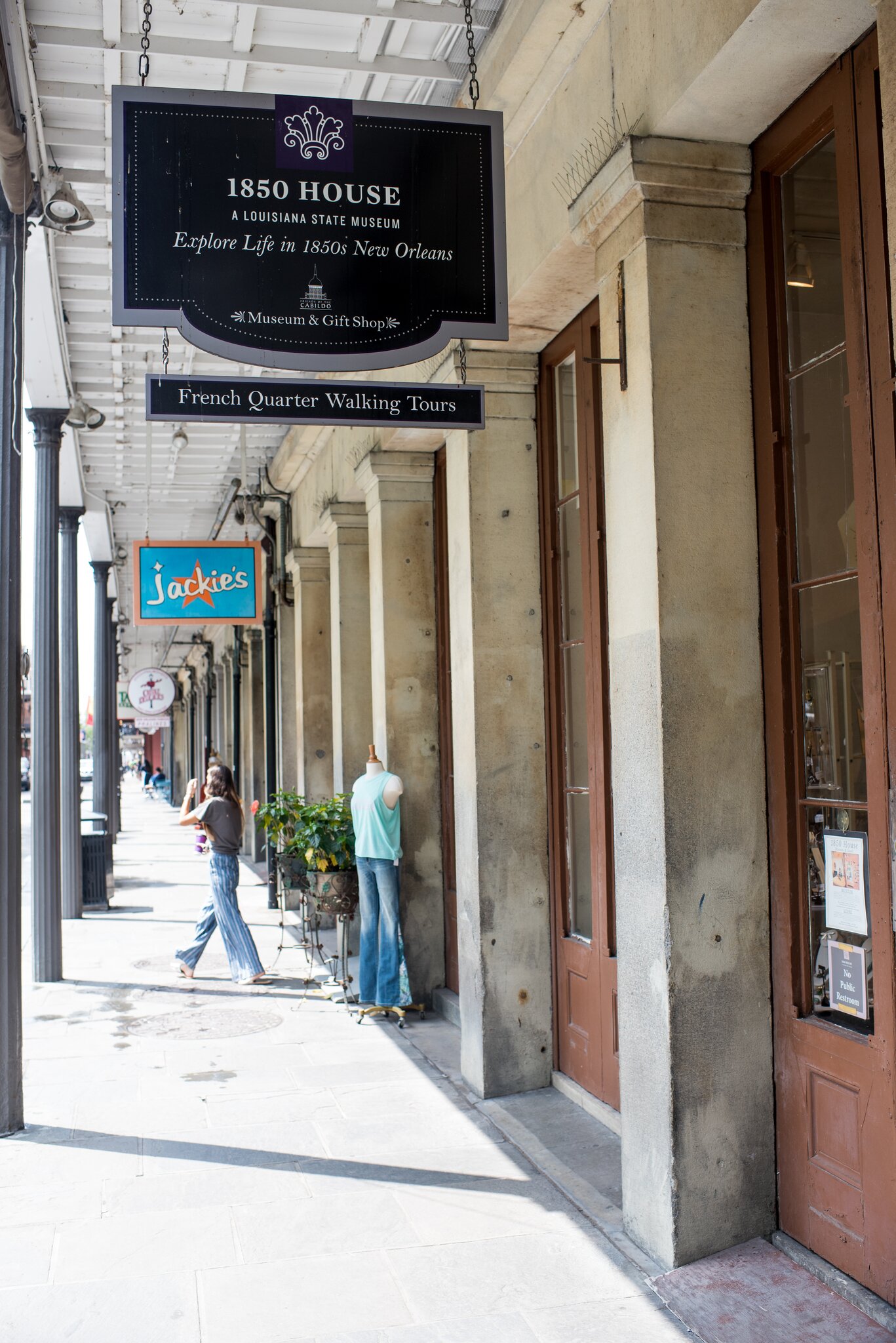 A hanging sign for 1850 House advertises the Louisiana State Museum site as a way for visitors to explore life in 1850s New Orleans.