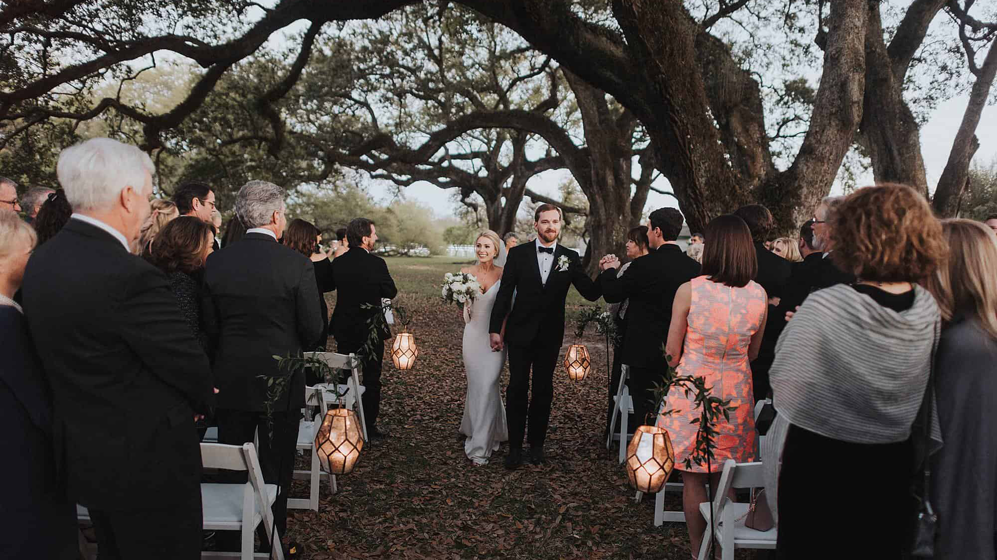 A newly wed couple walks down the aisle.