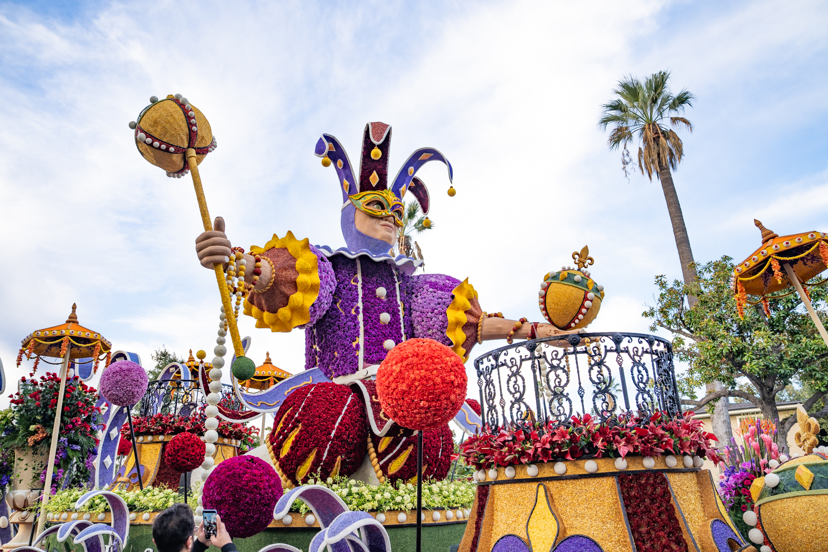 The 2024 Explore Louisiana Rose Parade float featured a large Mardi Gras jester surrounded by colorful decorations.