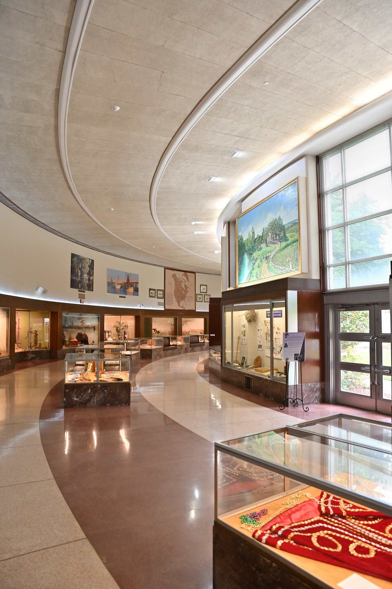 The interior of the Louisiana State Exhibit Museum features several glass cases filled with artifacts.