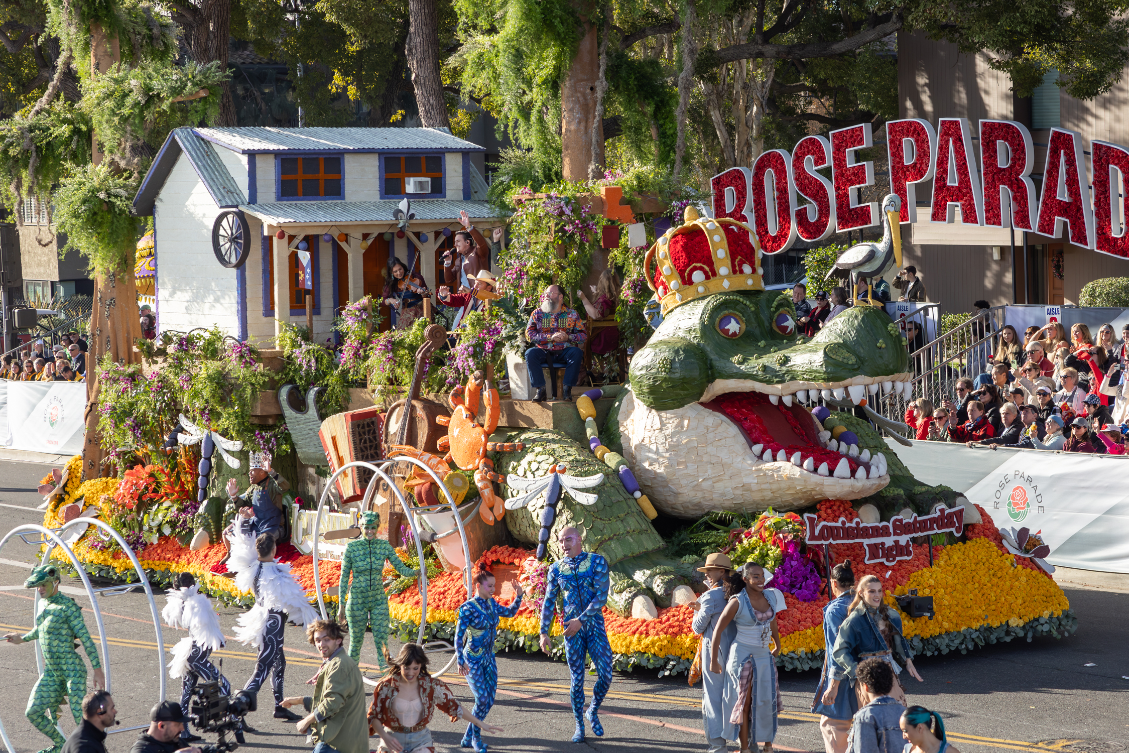 The 2025 Explore Louisiana Rose Parade float featured an alligator adorned with beads, carrying a Cajun dance hall, performers and pots of boiled seafood.