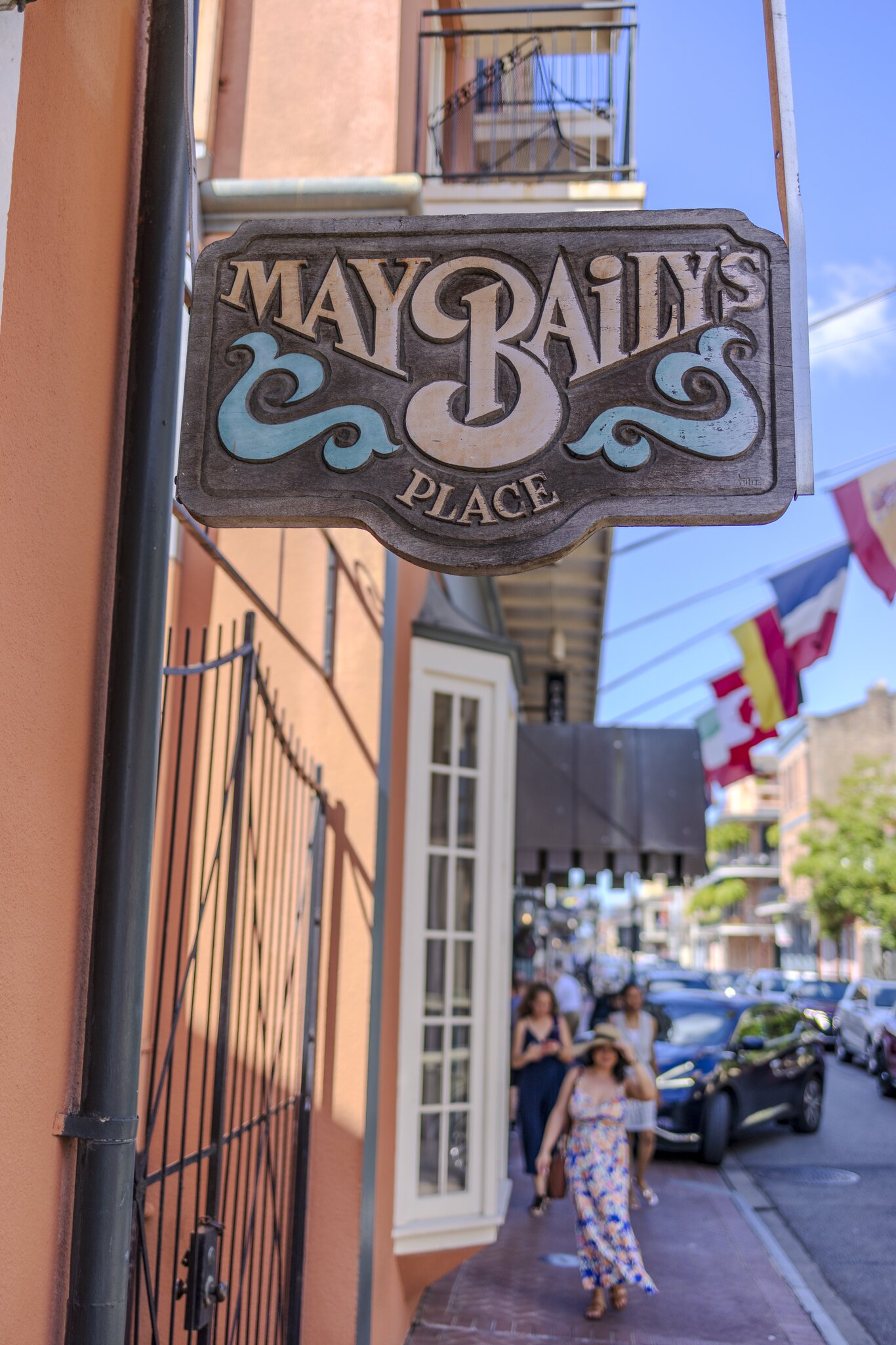 A handpainted wooden sign advertising May Baily’s Place hangs outside the Dauphine Hotel in New Orleans.