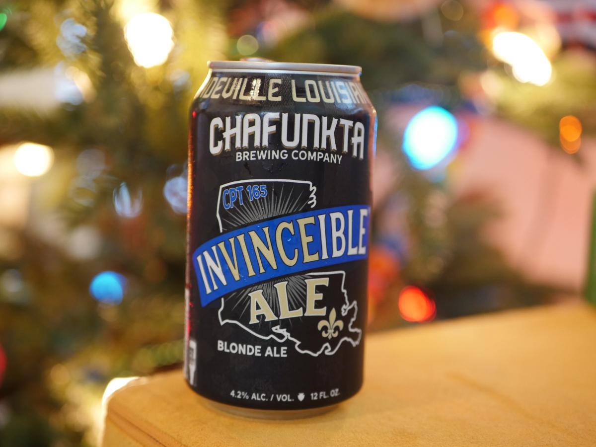 A can of “Invinceible Ale” from Chafunkta Brewing Company, with a tree lit with twinkling lights in the background.
