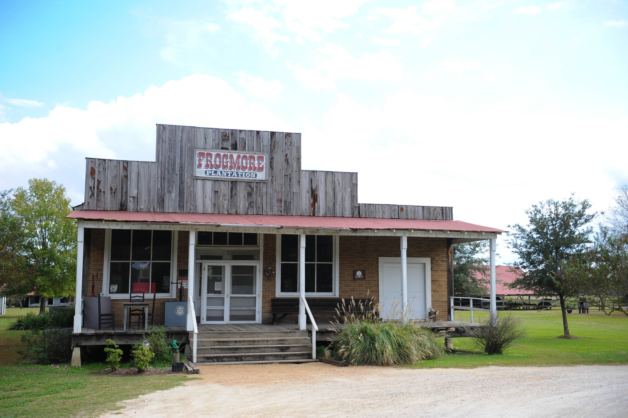 Old cotton gin interior with wooden machinery and baskets of raw cotton.