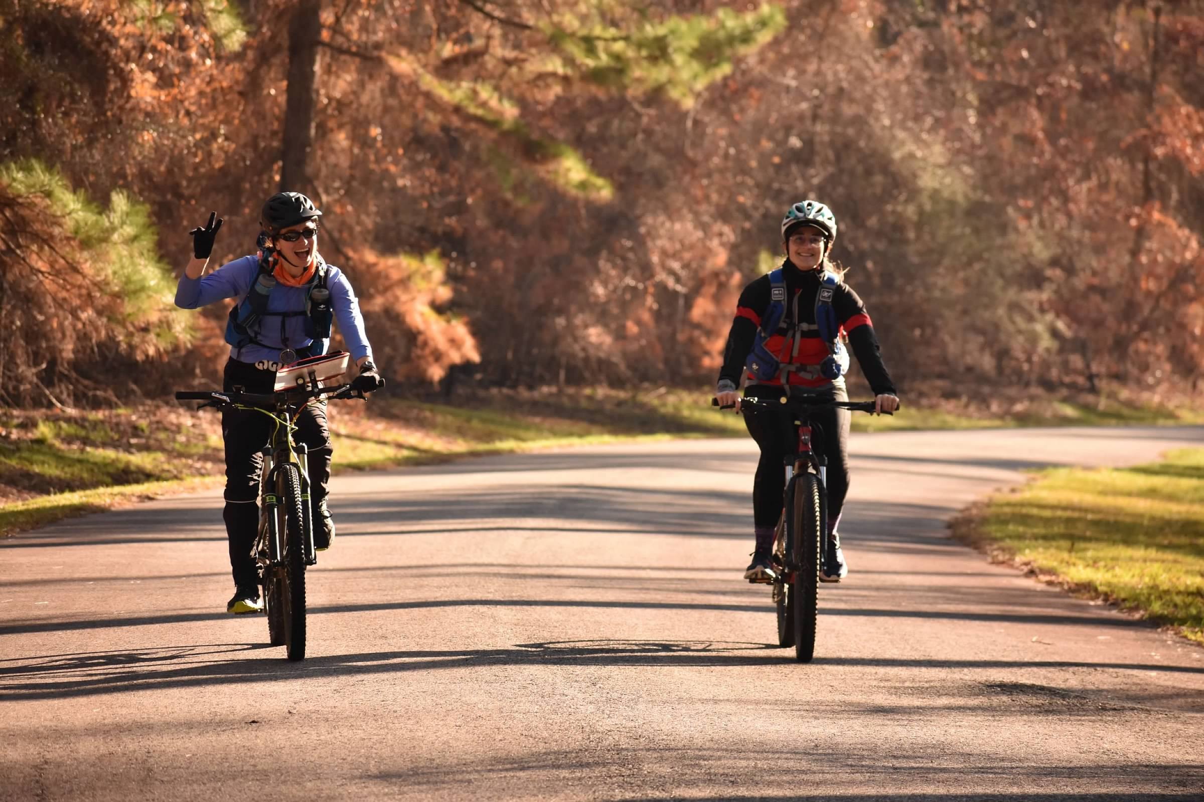 Two people biking a paved trail