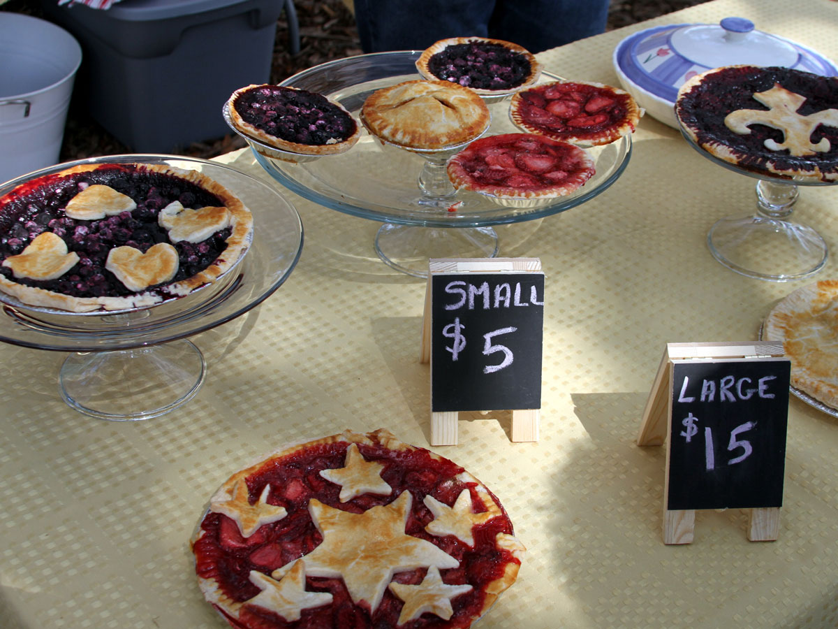 Lafayette Farmers and Artisan Market at the Horse Farm Table with fruit pies of varying sizes and price signs for small and large pies.