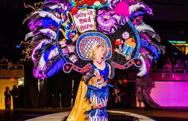 For Twelfth Night Extravaganza, a person dons a mad-hatter-themed Mardi Gras gown.