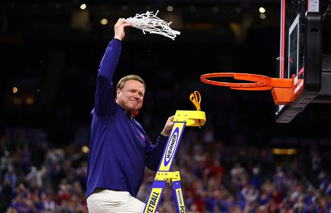 A male basketball coach cuts down the net after a championship win in New Orleans.