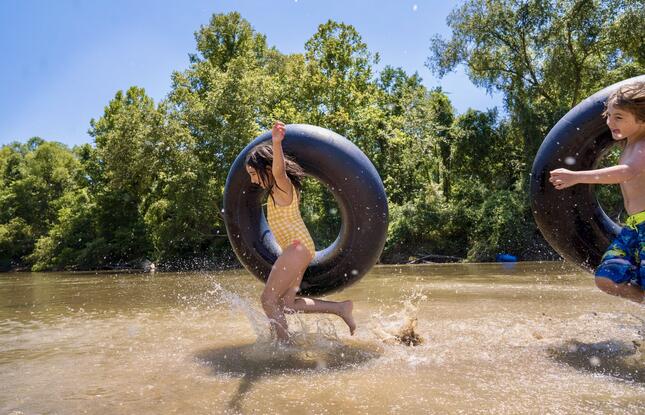 A girl runs along the water with an inner tube as she plays in Louisiana.