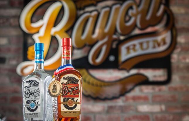 Bottles of white and dark rum against a brick wall at Bayou Rum in Lacassine, Louisiana.