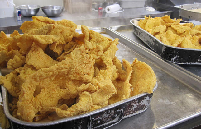 Trays of freshly fried, well seasoned catfish sit in a Louisiana kitchen.