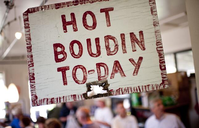 A sign reading “Hot Boudin To-Day” in red paint at Johnson's Boucanière in Lafayette, Louisiana