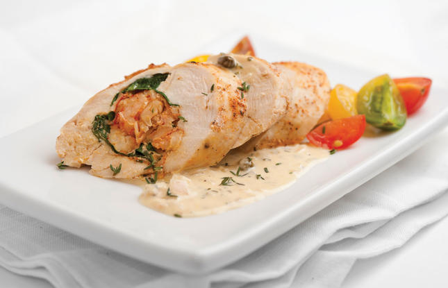 A tender chicken breast stuffed with flavorful crawfish, served with a creamy, herby sauce and topped with herbs.