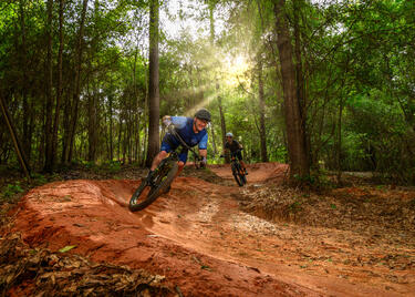 Two people enjoy the muddy mountain-biking trails at Bogue Chitto State Park.