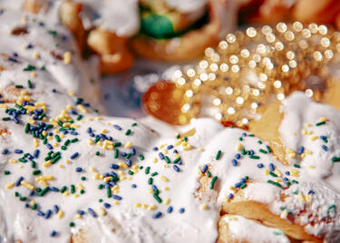 A close up of sprinkles on a king cake.