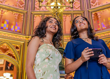Two travelers look at cathedral-like stained glass inside Louisiana's Old State Capitol.