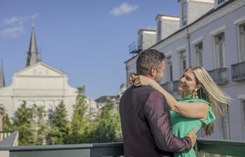 A couple embraces in front of the St. Louis Cathedral in New Orleans.
