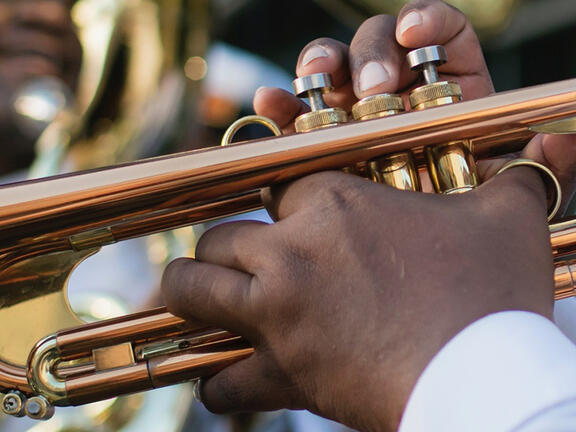 Hands playing a trumpet