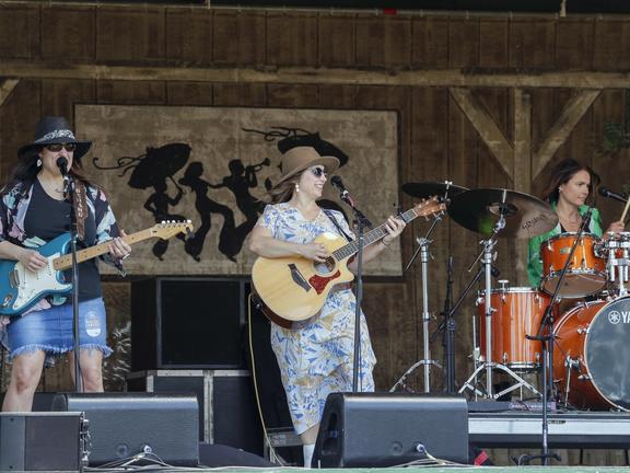 Singer playing guitar on stage during Jazz fest