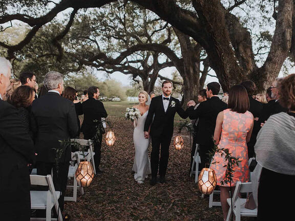 A newly wed couple walks down the aisle.