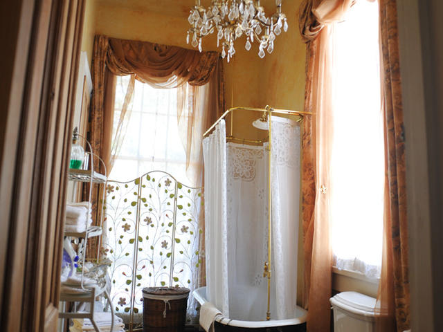 An elegant private bath with clawfoot tub/shower awaits guests in the Solarium Suite.