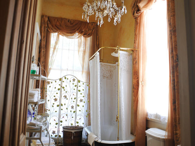 An elegant private bath with clawfoot tub/shower awaits guests in the Solarium Suite.