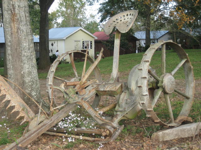 Old farm equipment with view of Cabin #6,#1 and #2 in the background