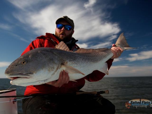 Fly Fishing Angler holding and Stud Louisiana Redfish