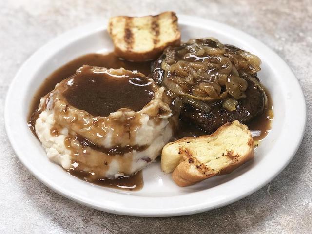 Hamburger Steak topped with onions and gravy served with mashed red potatoes