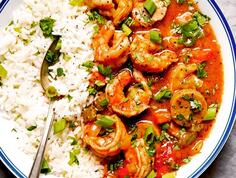 A white, blue-rimmed bowl holds rice and crawfish.