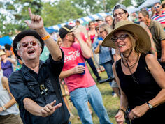 Two people dance among a crowd.