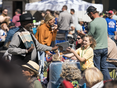 A child interacts with a festival host.