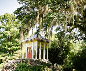 A lush tree towering over a white pavilion in Jungle Gardens on Avery Island, Louisiana.