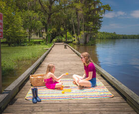A mother and daughter enjoy a picnic lunch on the boardwalk at Fairview-Riverside State Park.