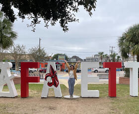 Lafayette letters in the park where person can stand in as the Y,  painted for the Ragin Cajuns