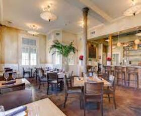 At Sukho Thai in New Orleans, Louisiana, the dining area is brightly lit with white walls, chic and understated overhead lights and dark wooden floors.