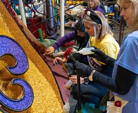 Volunteers decorate portions of the float for the Explore Louisiana float for the Rose Parade.
