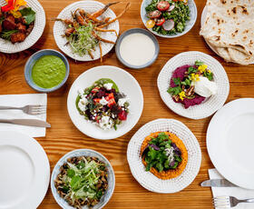 An array of Mediterranean dishes on a wood table at 1000 Figs in New Orleans