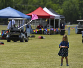 Young girl flying a kite at Kite Fest Louisiane'.