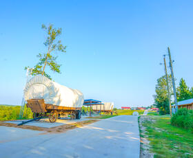 A covered wagon sits along a charming path at God's Country Resort.