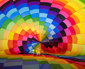 A pilot walks through the interior of a hot air balloon as it deflates.