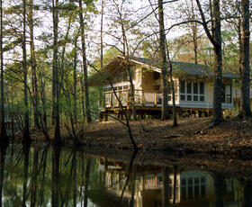 A cabin at Chemin-A-Haut State Park sits farther back on the shore, among the trees and wildlife of the area.